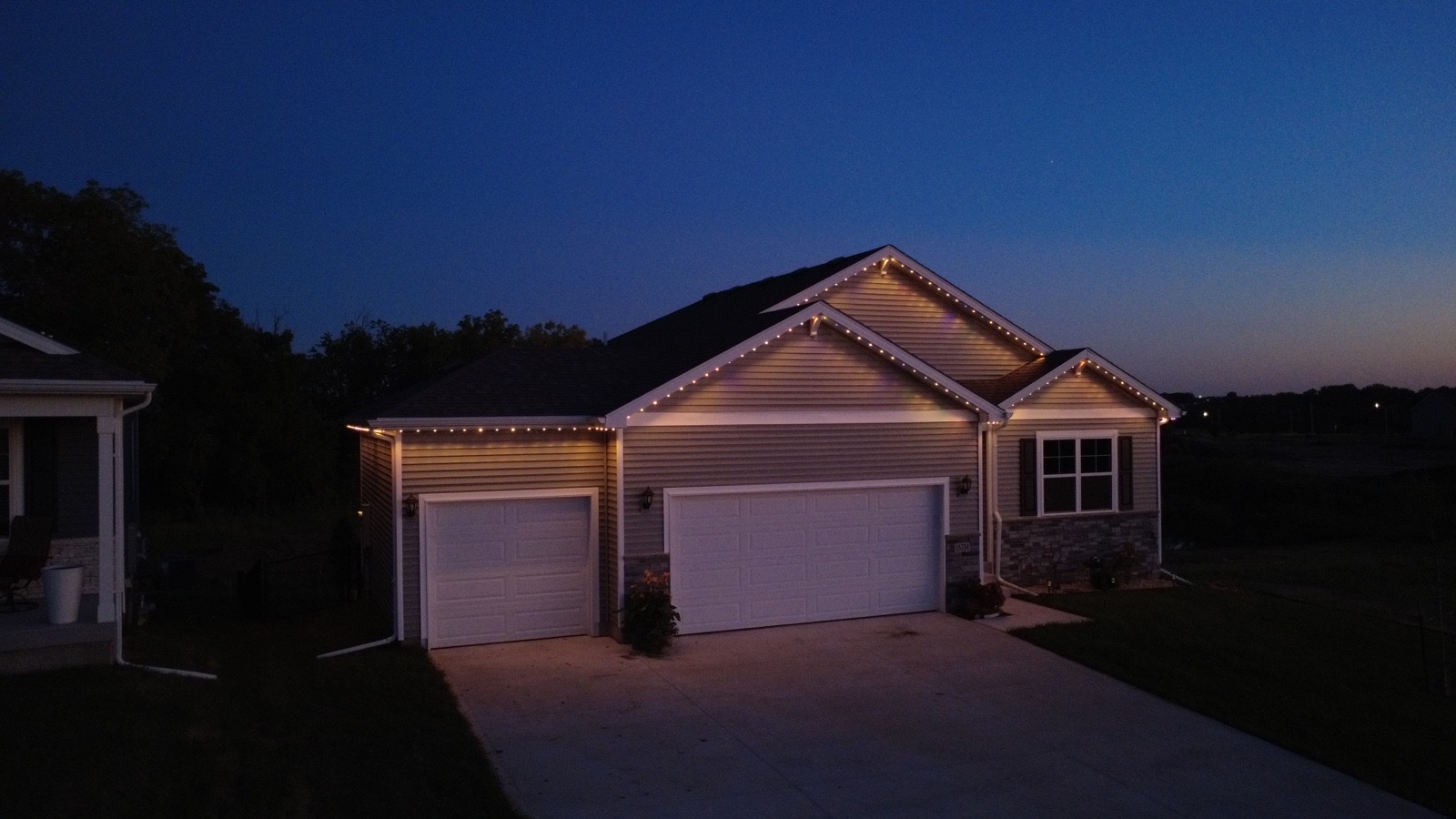 Home lit with warm permanent lighting at dusk